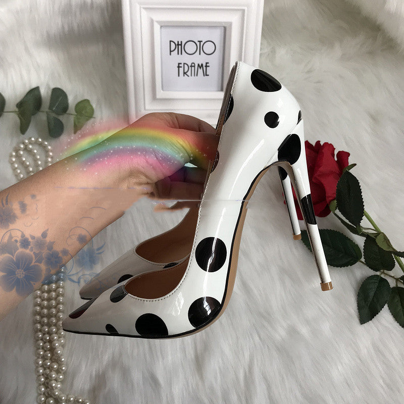 Tacones altos de piel de charol blanca con lunares negros