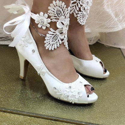 Nuevos zapatos de boda con tacón de aguja y cinta de flores y encaje blanco